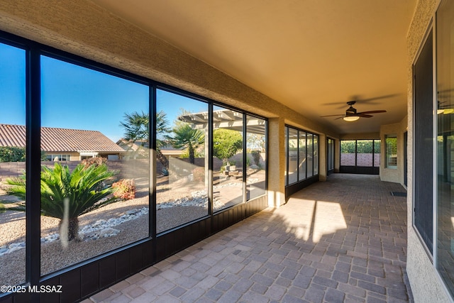 unfurnished sunroom featuring a healthy amount of sunlight and a ceiling fan