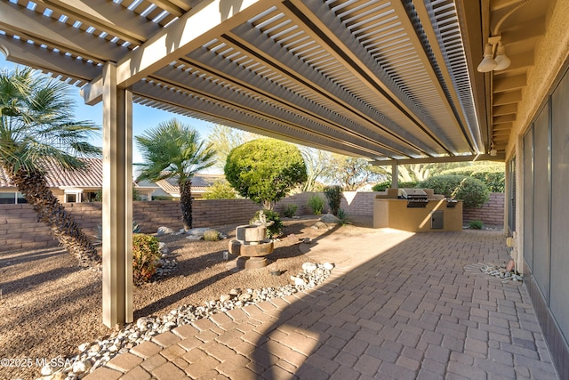 view of patio with area for grilling, a fenced backyard, and a pergola