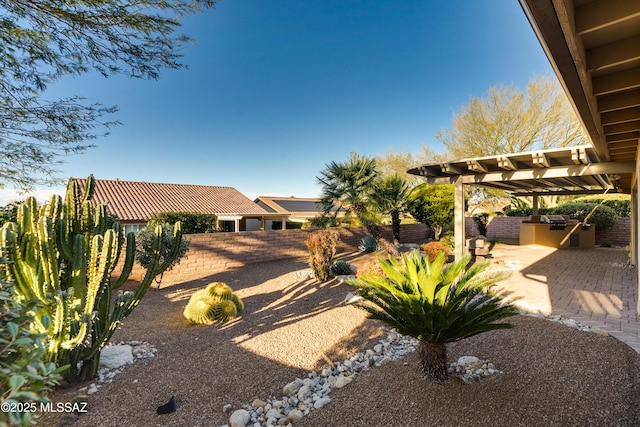 view of yard with exterior kitchen, a pergola, fence, and a patio