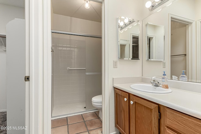 full bath with toilet, tile patterned flooring, a tile shower, and vanity