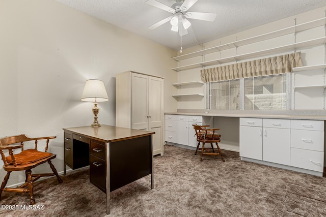 office area with a textured ceiling, ceiling fan, and dark carpet