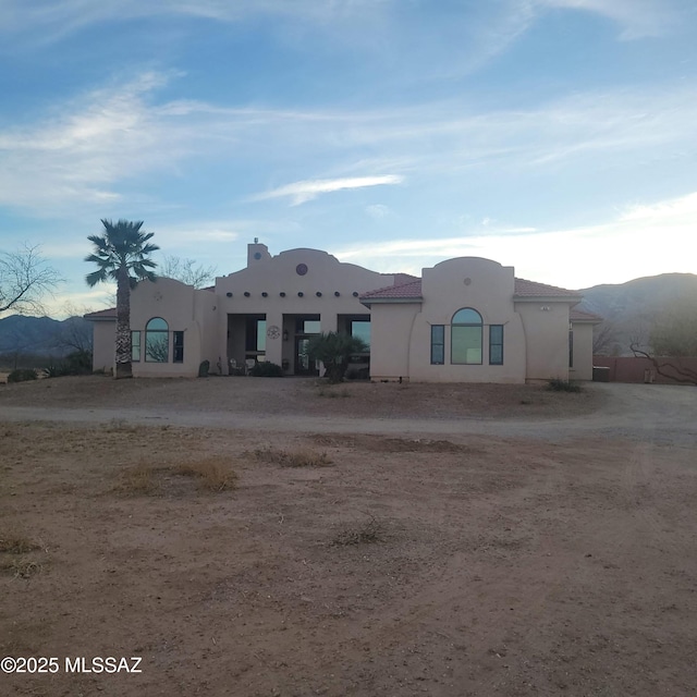 pueblo revival-style home featuring a mountain view and stucco siding