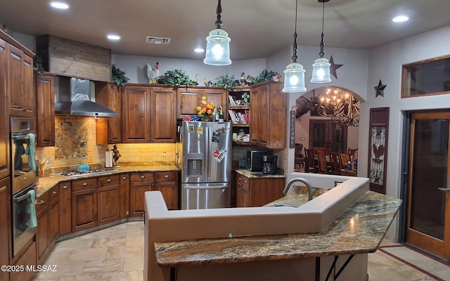 kitchen with visible vents, appliances with stainless steel finishes, hanging light fixtures, wall chimney range hood, and open shelves