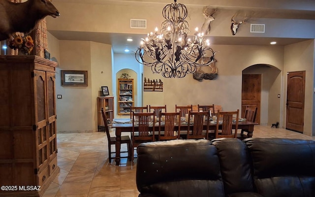 dining room with arched walkways, visible vents, and baseboards