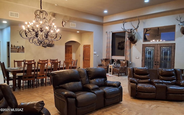 living area with arched walkways, french doors, visible vents, and recessed lighting