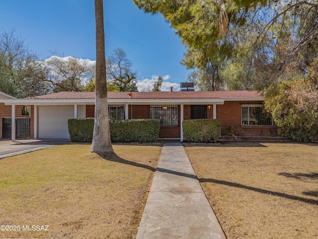 ranch-style house featuring a garage, brick siding, concrete driveway, and a front lawn