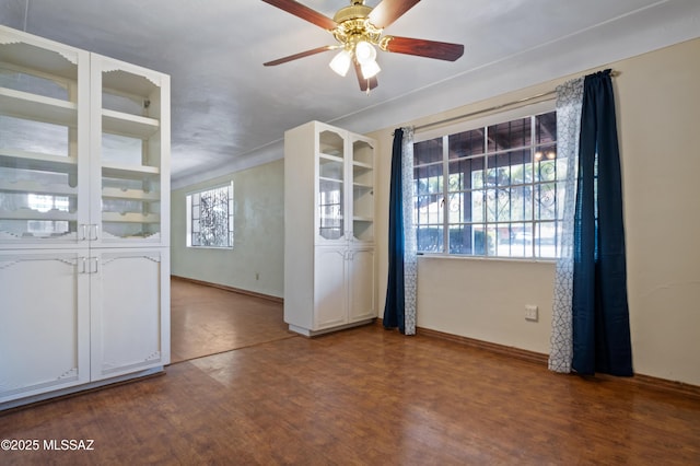 interior space with wood finished floors, baseboards, and ceiling fan