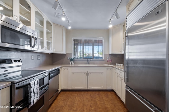 kitchen featuring a sink, dark wood-style floors, white cabinetry, appliances with stainless steel finishes, and glass insert cabinets