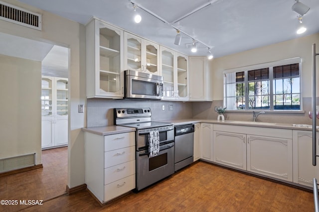 kitchen with dark wood-style flooring, visible vents, appliances with stainless steel finishes, and a sink