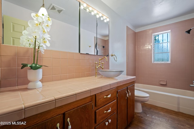 bathroom with visible vents, toilet, backsplash, wood finished floors, and vanity