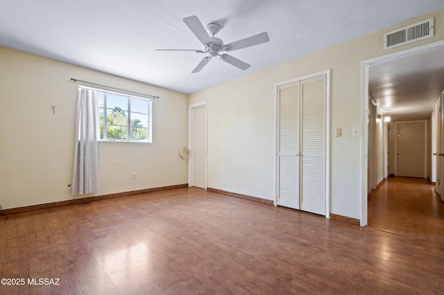 unfurnished bedroom with visible vents, ceiling fan, baseboards, wood finished floors, and a closet