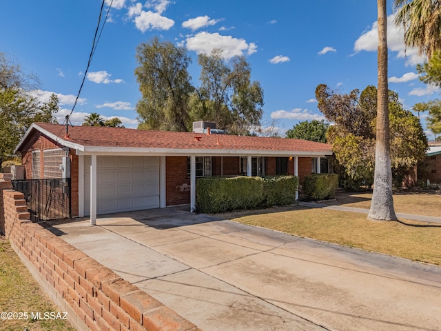 ranch-style home with brick siding, a garage, driveway, and a front yard