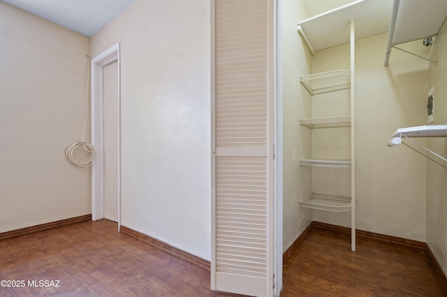 walk in closet with wood finished floors