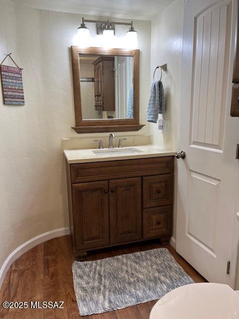 bathroom with vanity, baseboards, and wood finished floors