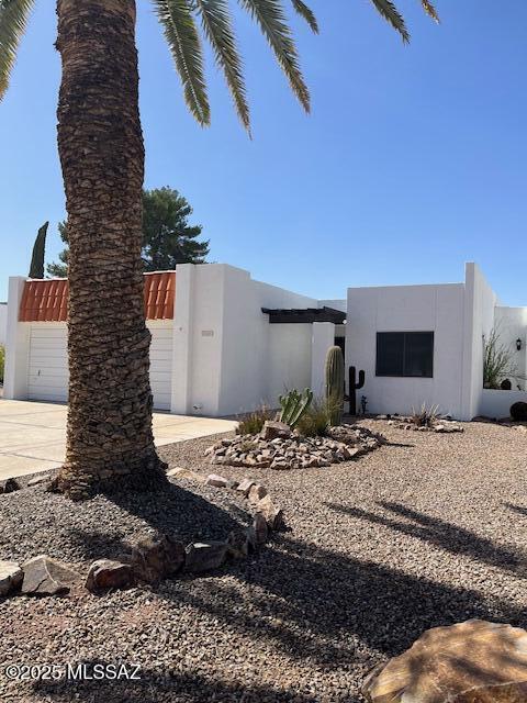 view of side of property with fence and stucco siding