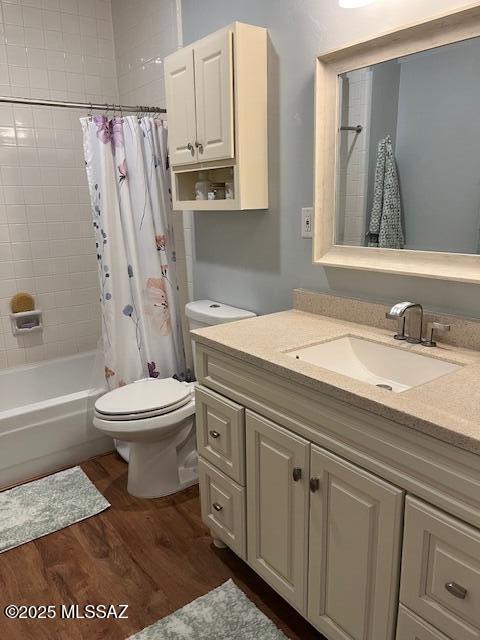 bathroom with toilet, shower / tub combo, wood finished floors, and vanity