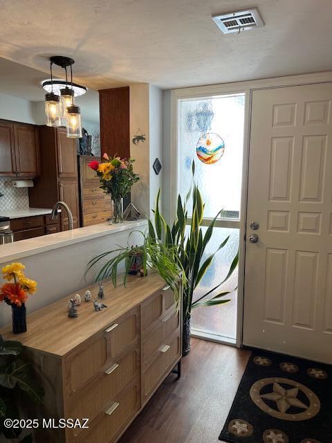 entrance foyer featuring dark wood-style floors and visible vents