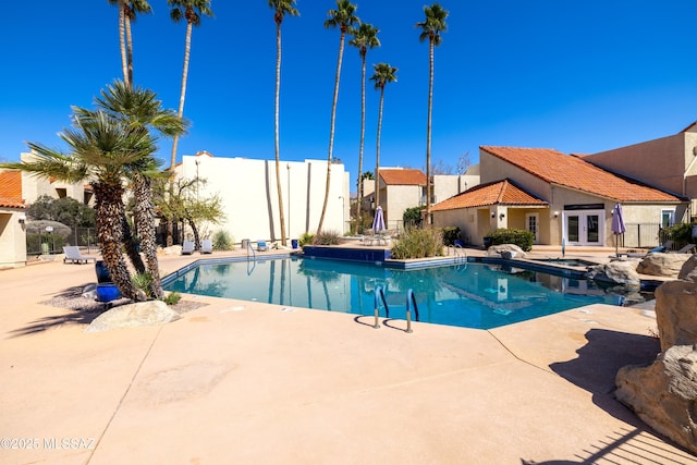 pool featuring a patio, french doors, and fence