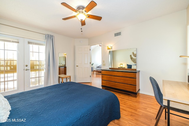 bedroom with a ceiling fan, visible vents, light wood finished floors, baseboards, and french doors