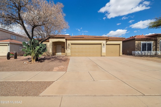 view of front of property with an attached garage, driveway, and stucco siding