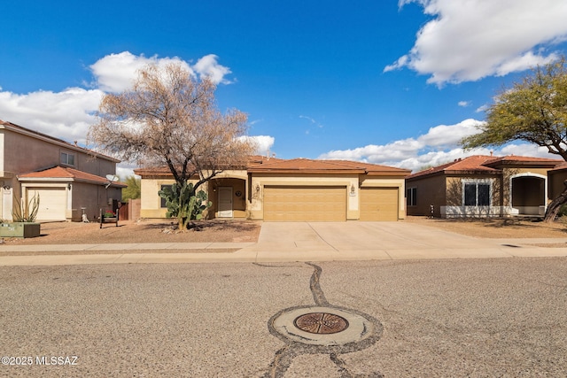 view of front facade with stucco siding, concrete driveway, an attached garage, and a tiled roof