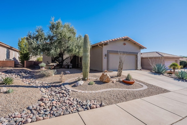 view of front of property with a garage, fence, driveway, a tiled roof, and stucco siding