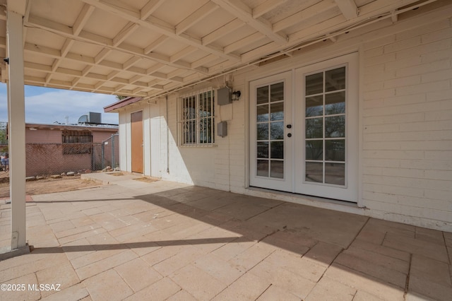 view of patio featuring french doors and fence