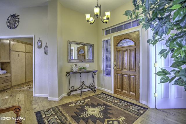 13517 N Heritage Gateway Ave, Marana, AZ 85658 - entryway featuring a high ceiling, baseboards, light wood-type flooring, and a chandelier