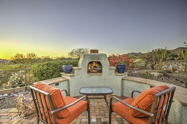 13517 N Heritage Gateway Ave, Marana, AZ 85658 - patio terrace at dusk with a lit fireplace and fence