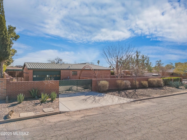 view of front facade with brick siding, a fenced front yard, and a gate