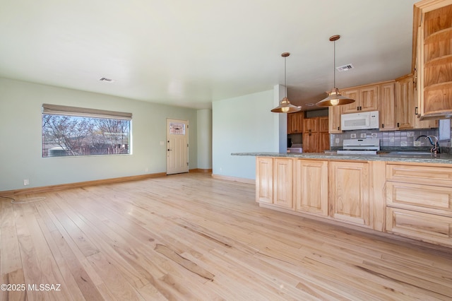 kitchen featuring visible vents, light wood-style flooring, backsplash, a sink, and white appliances