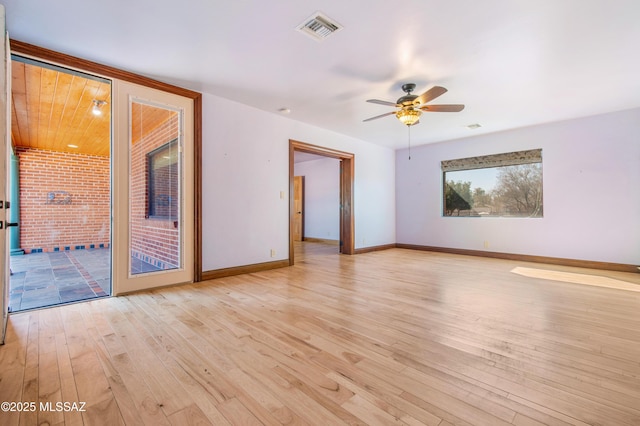 empty room featuring visible vents, a ceiling fan, light wood-style flooring, and baseboards