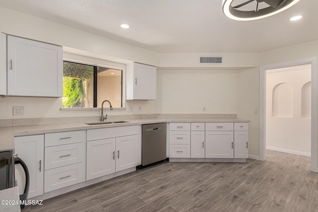 kitchen with visible vents, dishwasher, light wood-style floors, white cabinetry, and a sink