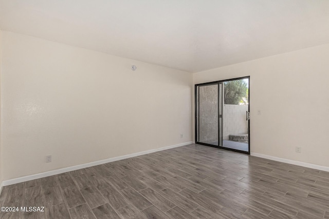 spare room featuring baseboards and wood finished floors