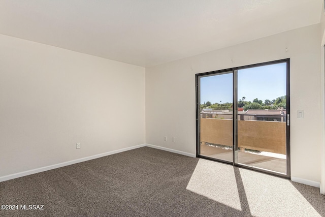 carpeted spare room featuring baseboards