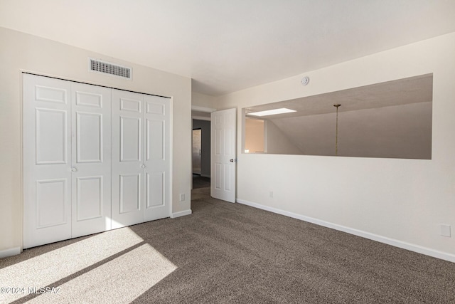 unfurnished bedroom with dark carpet, visible vents, and baseboards