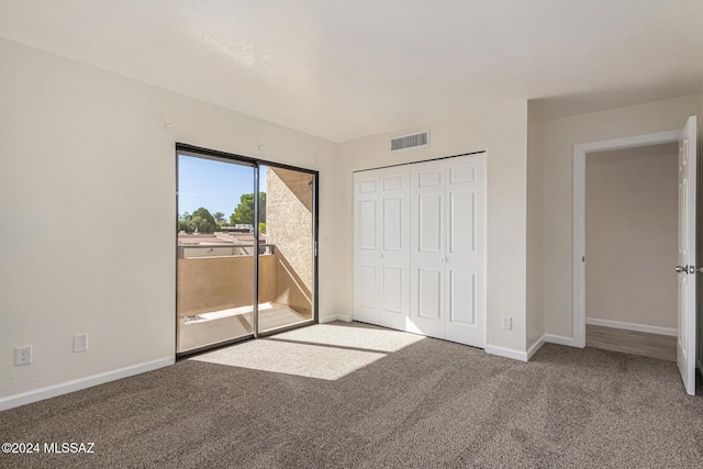 unfurnished bedroom with carpet floors, access to outside, visible vents, and baseboards