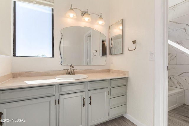 bathroom with vanity, baseboards, and wood finished floors