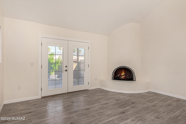 unfurnished living room with dark wood-style floors, french doors, a fireplace, and baseboards