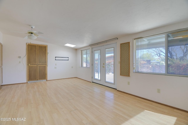 spare room with light wood-style floors, lofted ceiling, french doors, and baseboards