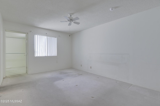 carpeted empty room featuring a textured ceiling and ceiling fan