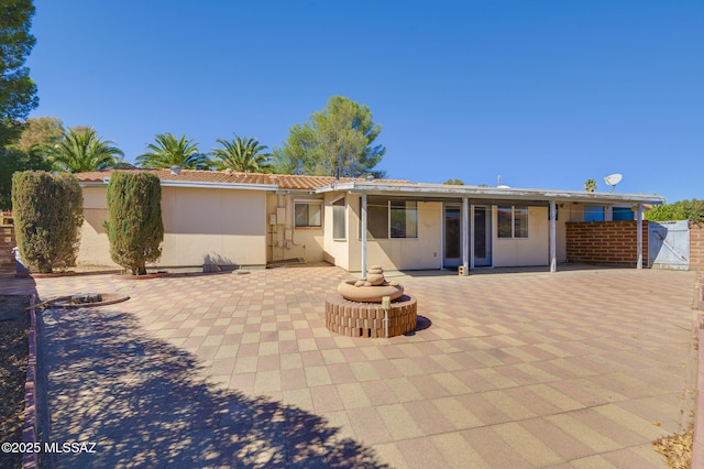 back of property featuring a patio, stucco siding, a tile roof, and fence