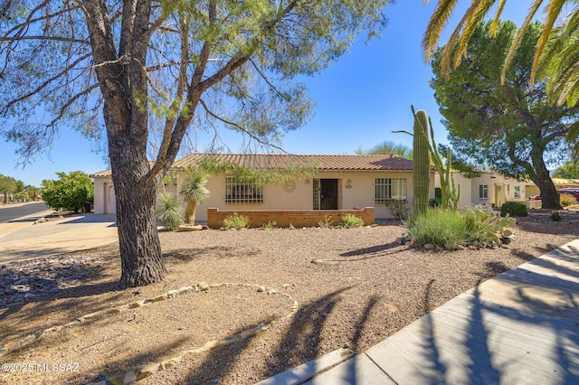 ranch-style home featuring brick siding, stucco siding, an attached garage, driveway, and a tiled roof