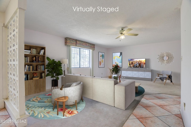 tiled living room featuring carpet flooring, ceiling fan, and a textured ceiling