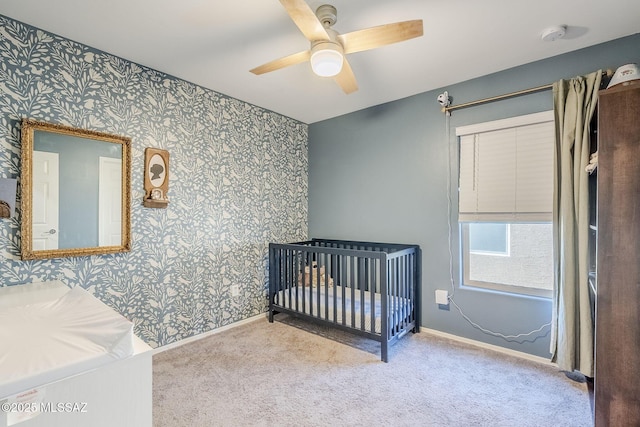 bedroom featuring carpet floors, wallpapered walls, ceiling fan, and baseboards