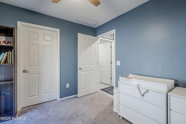 bedroom with light carpet, ceiling fan, visible vents, and baseboards