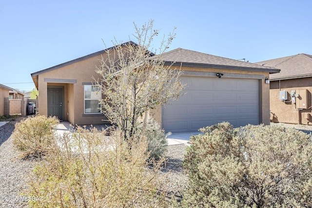 ranch-style home featuring an attached garage, fence, and stucco siding