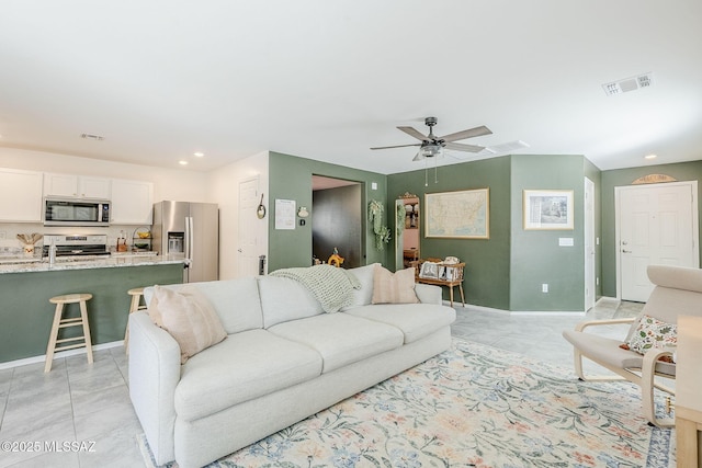 living room featuring light tile patterned floors, baseboards, visible vents, a ceiling fan, and recessed lighting