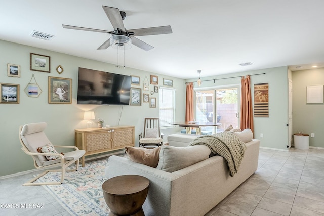 living room featuring baseboards, visible vents, a ceiling fan, and light tile patterned flooring