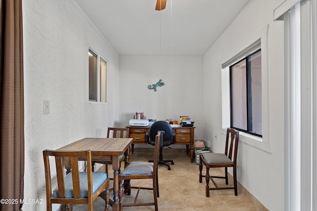 office area featuring a textured wall and ceiling fan